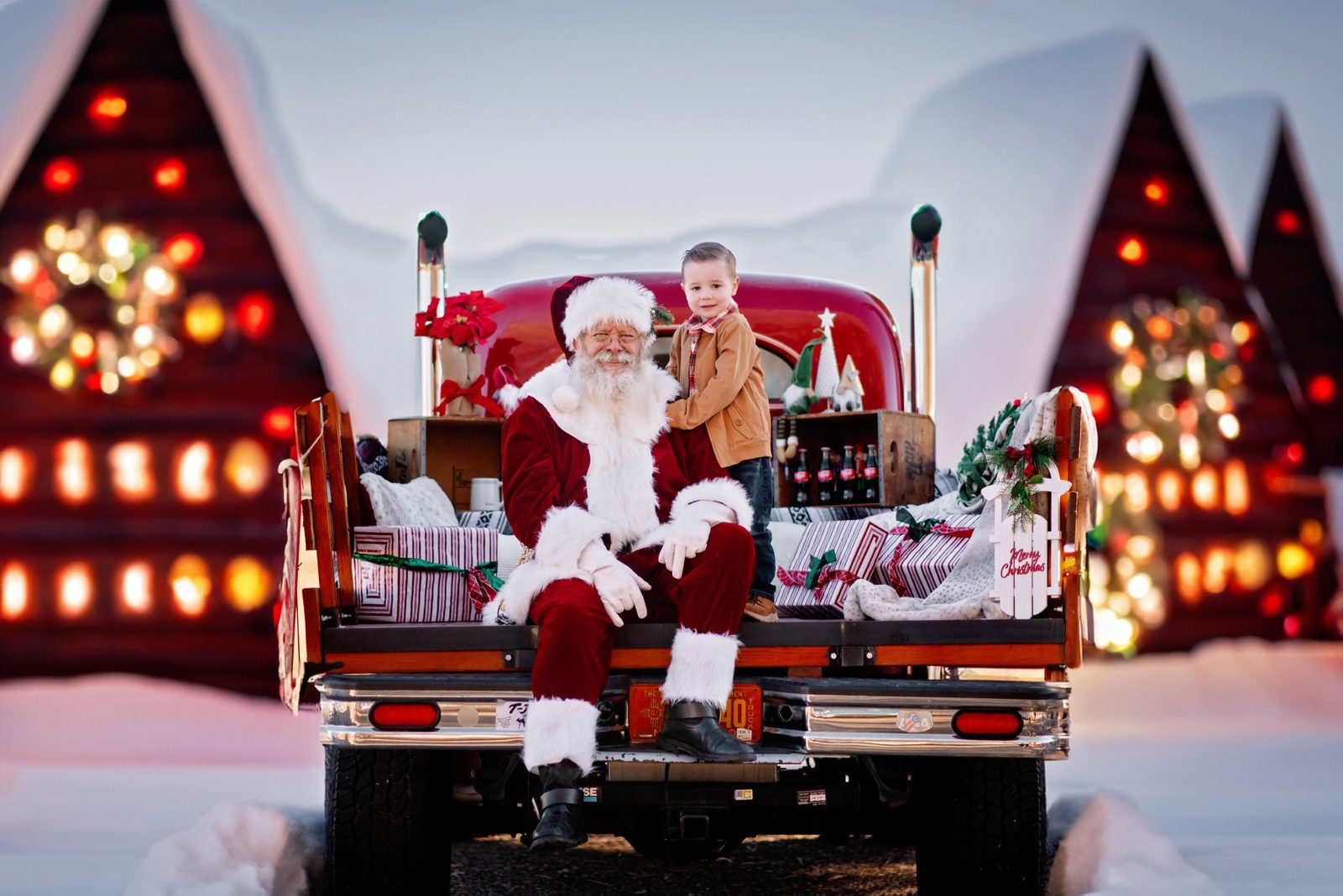 Santa Michael with a boy on the tailgate of a red truck